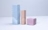 Three Covey skincare box packaging designs from tallest to shortest in studio lighting on a blue background