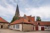 Photo of the forge building with a church in the background at Gut Bennigsen estate grounds in Bennigsen, Germany.