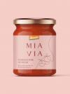 Mia Via packaging design mockup featuring a centered jar of tomato sauce on a pink background