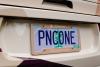 View of a number plate of a car with the letters PNCONE on it. The number plate holder reads "Pinecone" and "Childcare done nicely".