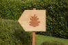 Wooden wayfinding post with a pinecone symbol on it in the garden of Pinecone Childcare in Portland, Oregon.