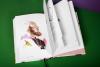 Symrise Perfurmers Compendium index book and label cover photographed from above, open faced, showing an illustration, in a studio environment with a green background