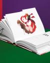 Symrise Perfurmers Compendium index book and label cover photographed open faced, showing an illustration, in a studio environment with colorful walls of red, green and purple